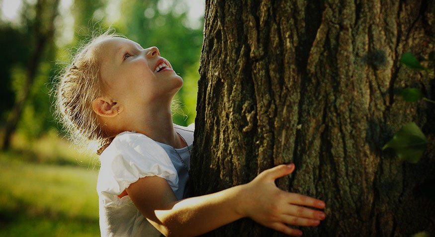 Child hugging a tree.