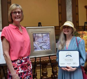 Lt. Governor Suzanne Crouch with the Charlene Marsh painting that hangs in her office through May 2018: Ice Cold Reflections, January 21, 2016, an oil painting done on location in Yellowwood State Forest.